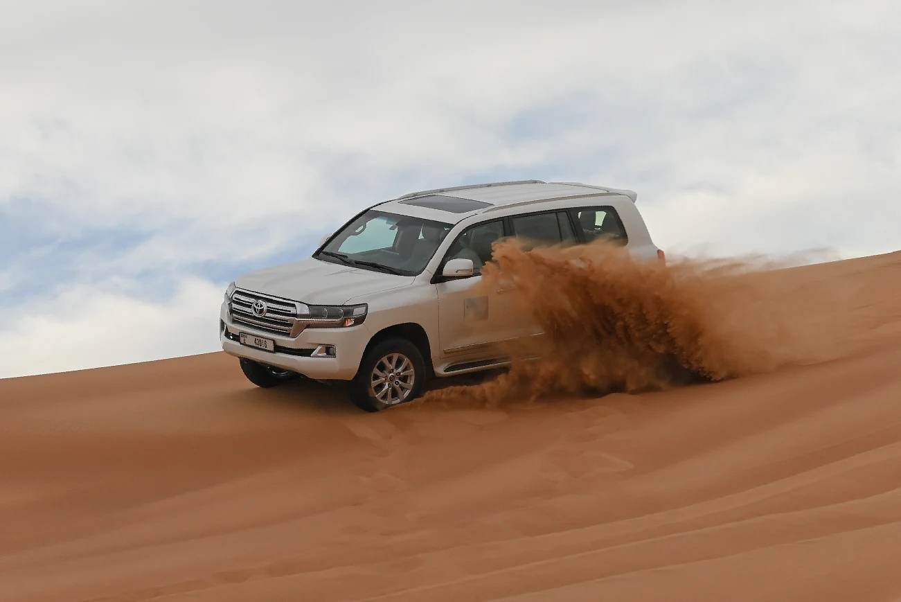 4x4 vehicles dune bashing across the red dunes of Lahbab, Dubai