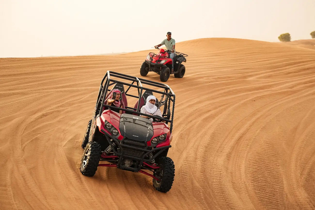 Kawasaki buggy driving across the desert dunes