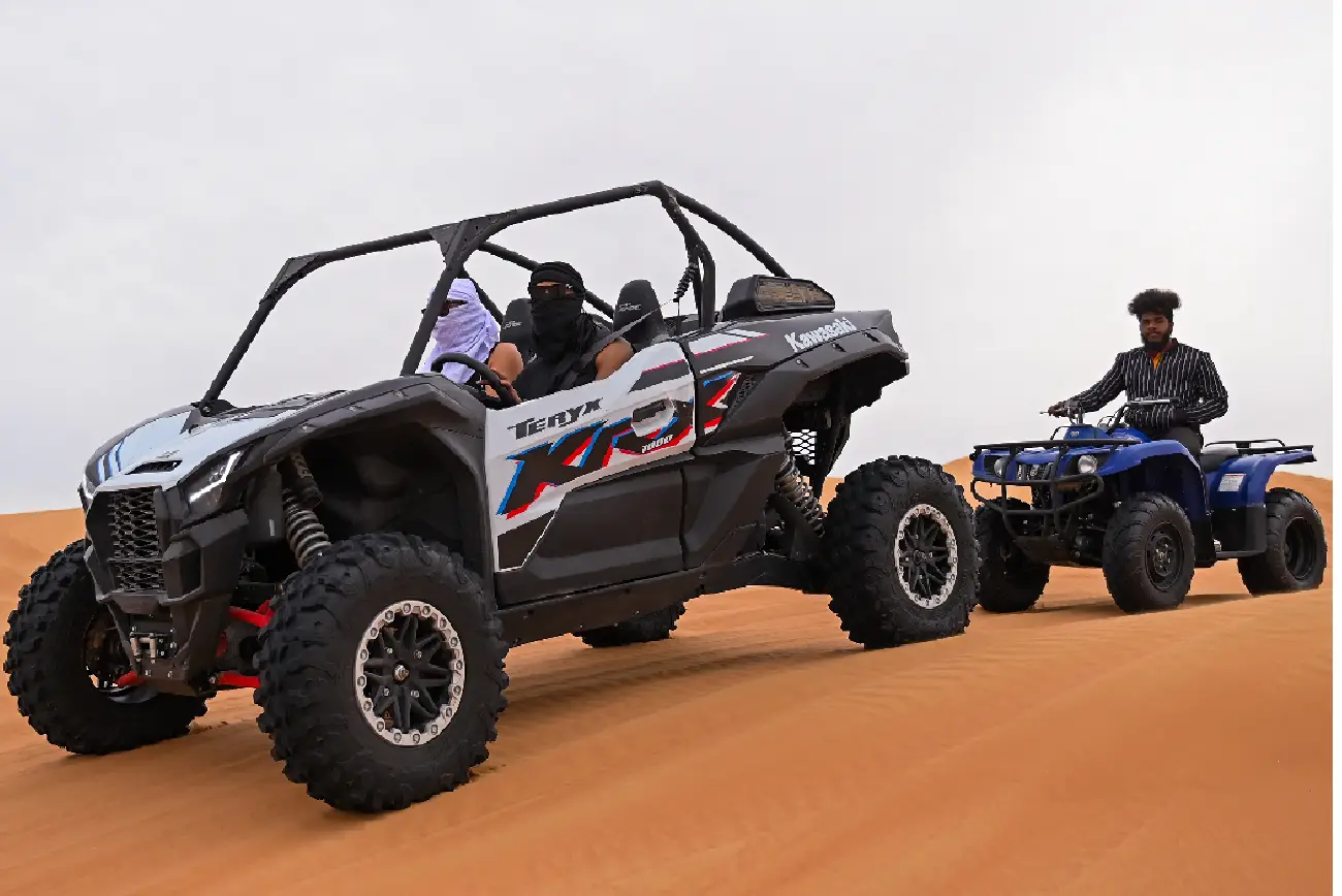 Polaris buggy climbing a sand dune